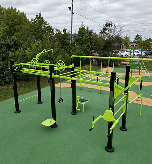 une station de cross fit en plein air devant un jeu pour enfant.