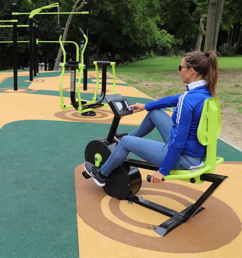 femme en train de pédaler sur un vélo semi allongé en plein air.