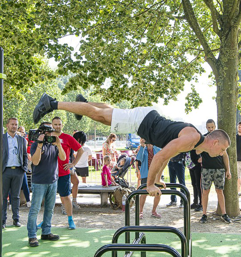 homme en planche devant un public et une caméra sur un espace extérieur.