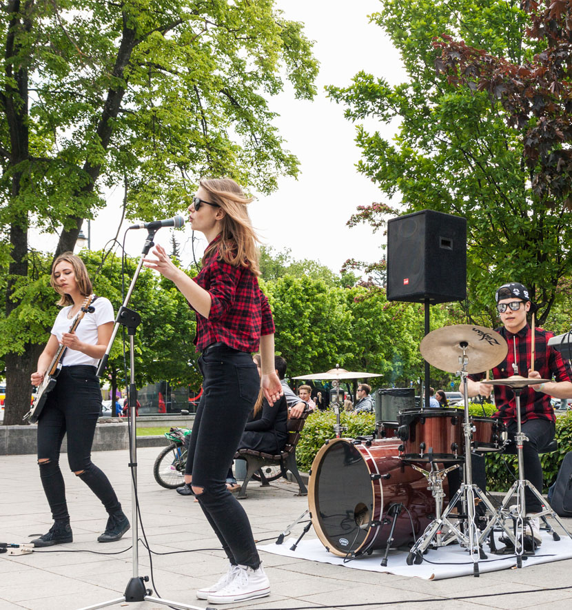 femme qui chante dans la rue avec un groupe de musique.