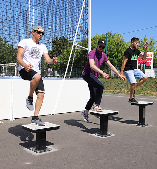 trois sportifs sautent sur des plyo box en plein air.