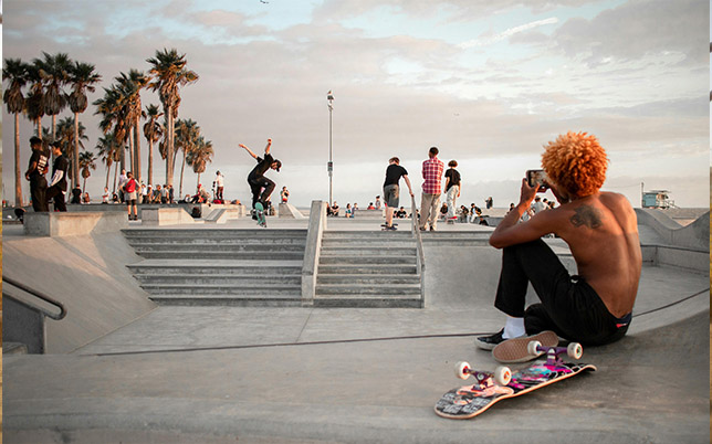 un skateur saute des marches dans un skatepark exterieur.