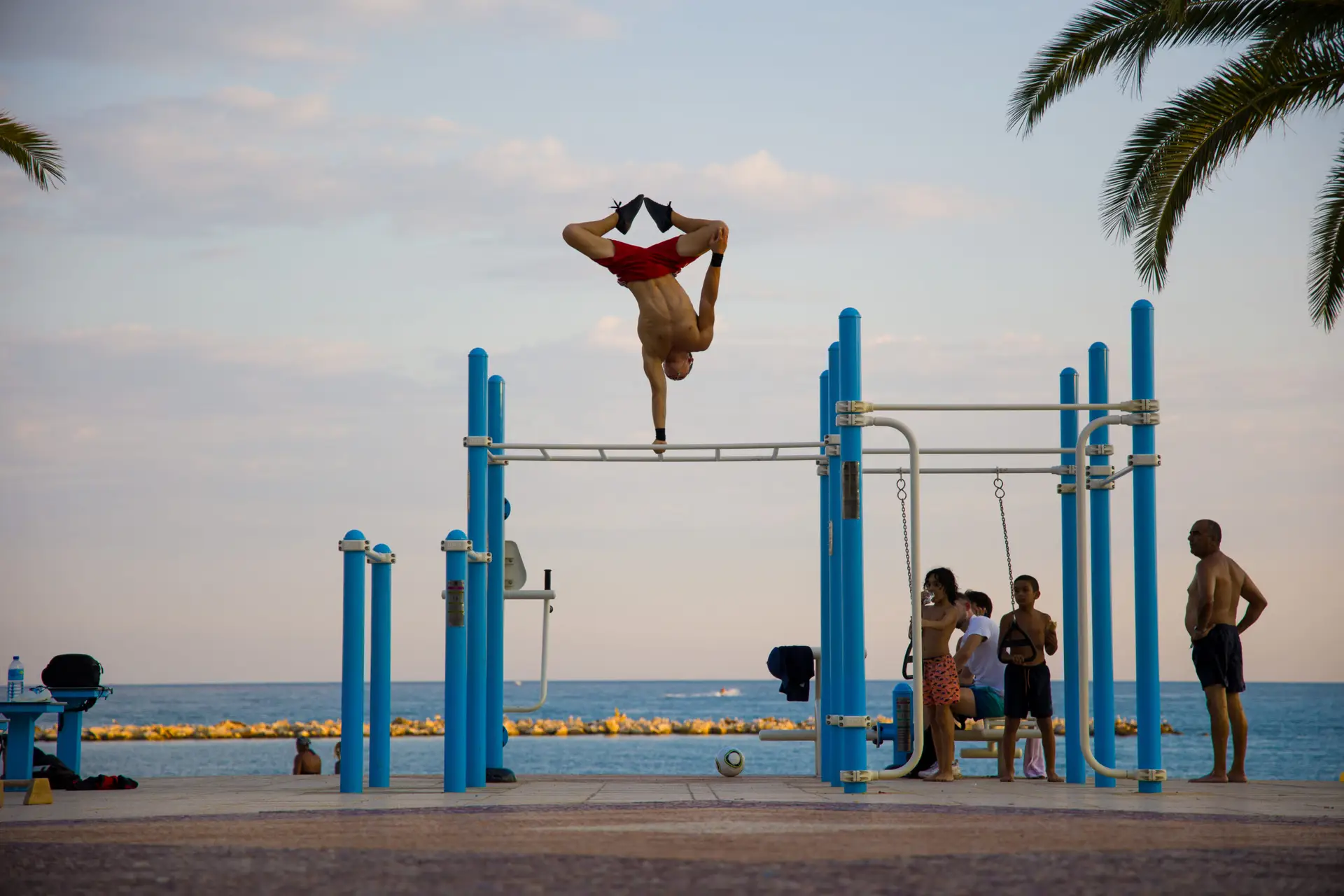 Mouvement de force effectué sur une station de streetworkout face à la mer et en extérieur.