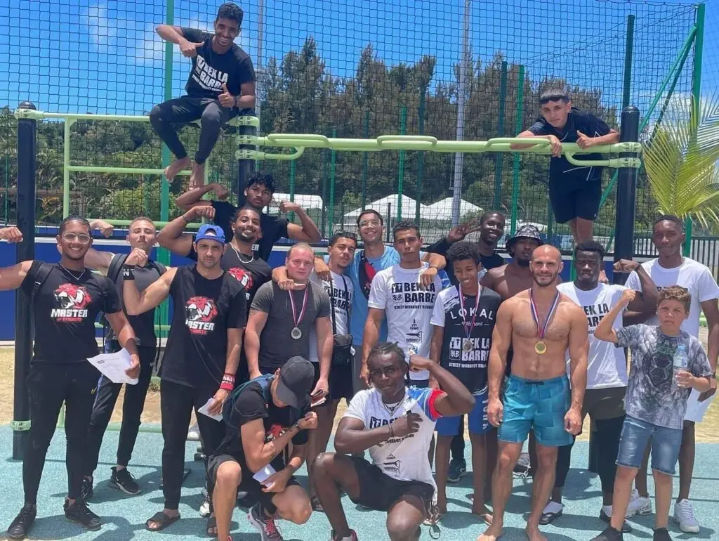 groupe de jeunes hommes avec des médailles posant sur une structure de streetworkout.