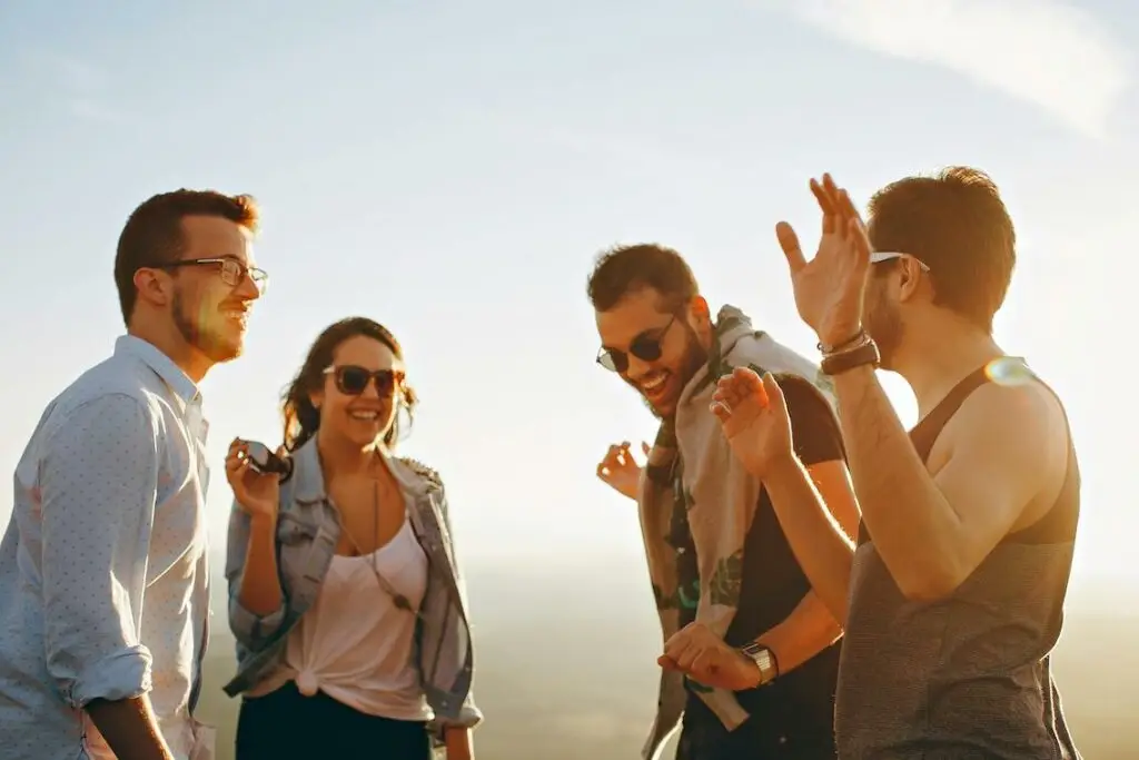 groupe de jeune souriant au coucher de soleil.